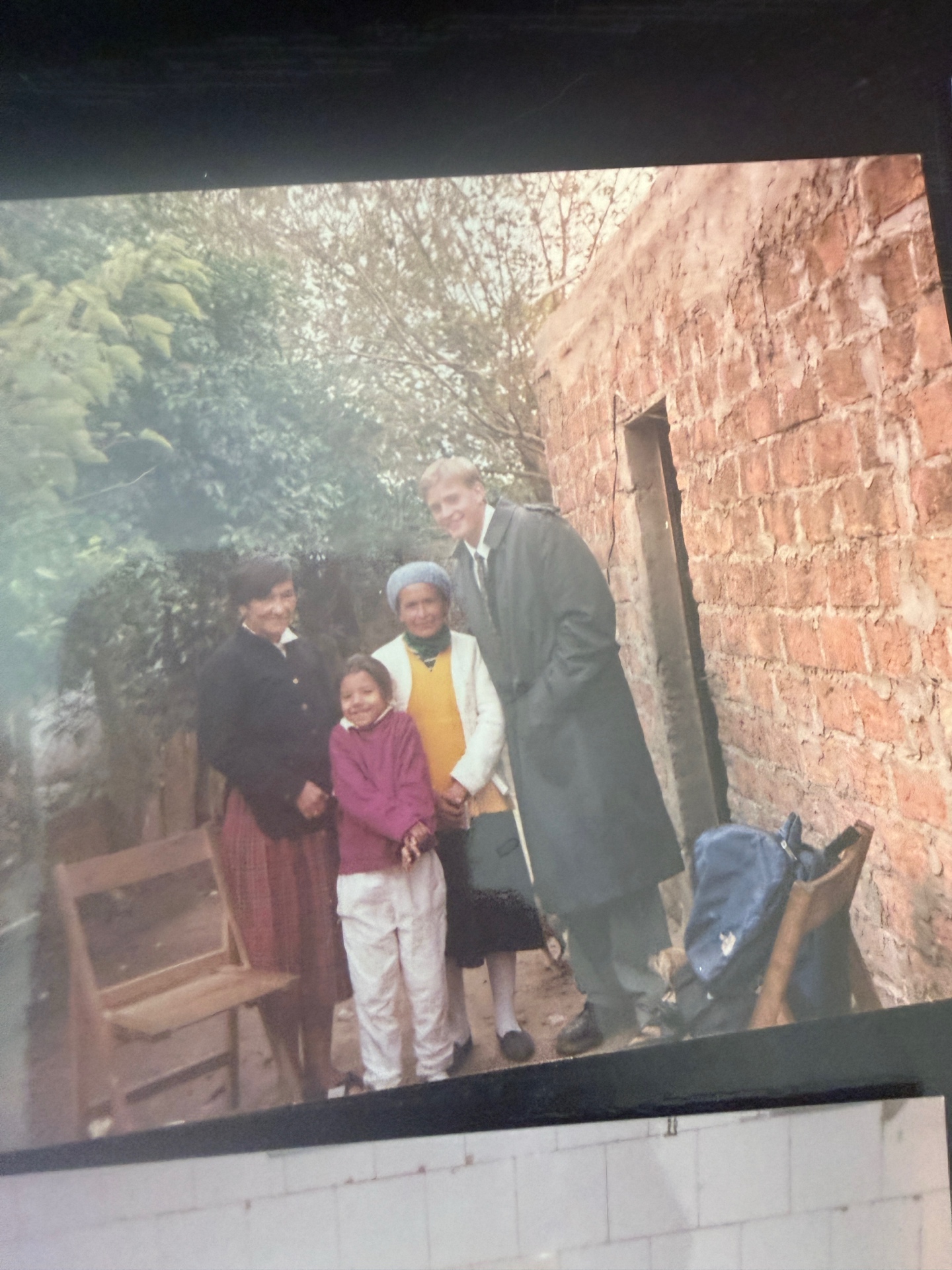 Dave with Argentine grandmothers and a young girl outside their adobe home